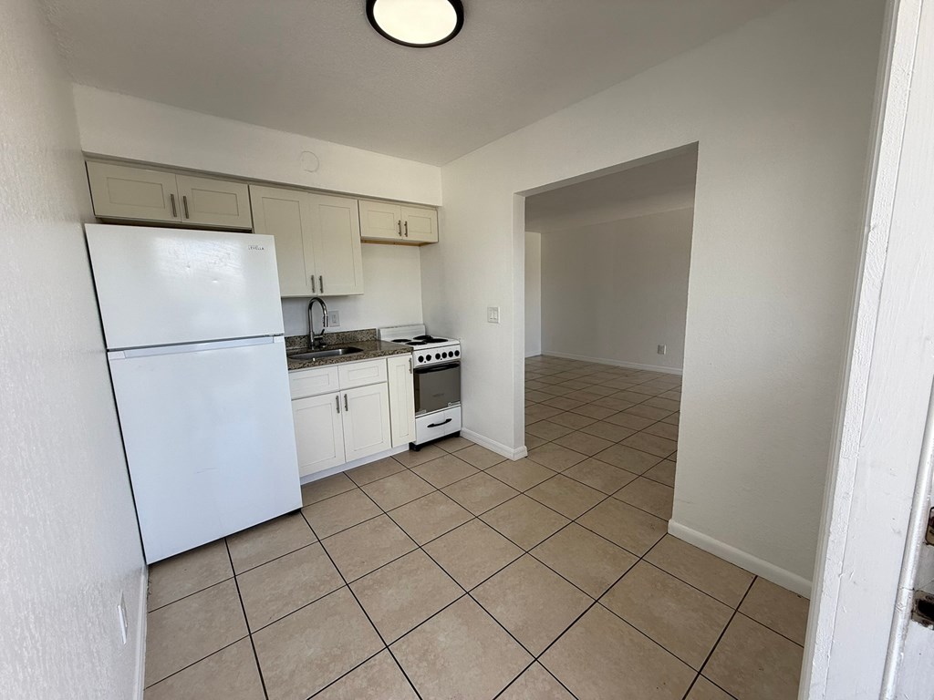 A kitchen with white appliances and cabinets.