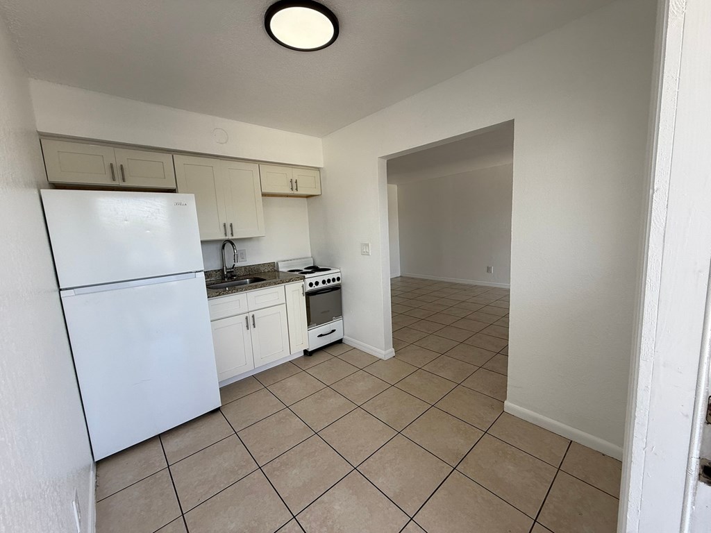 A kitchen with white appliances and cabinets.