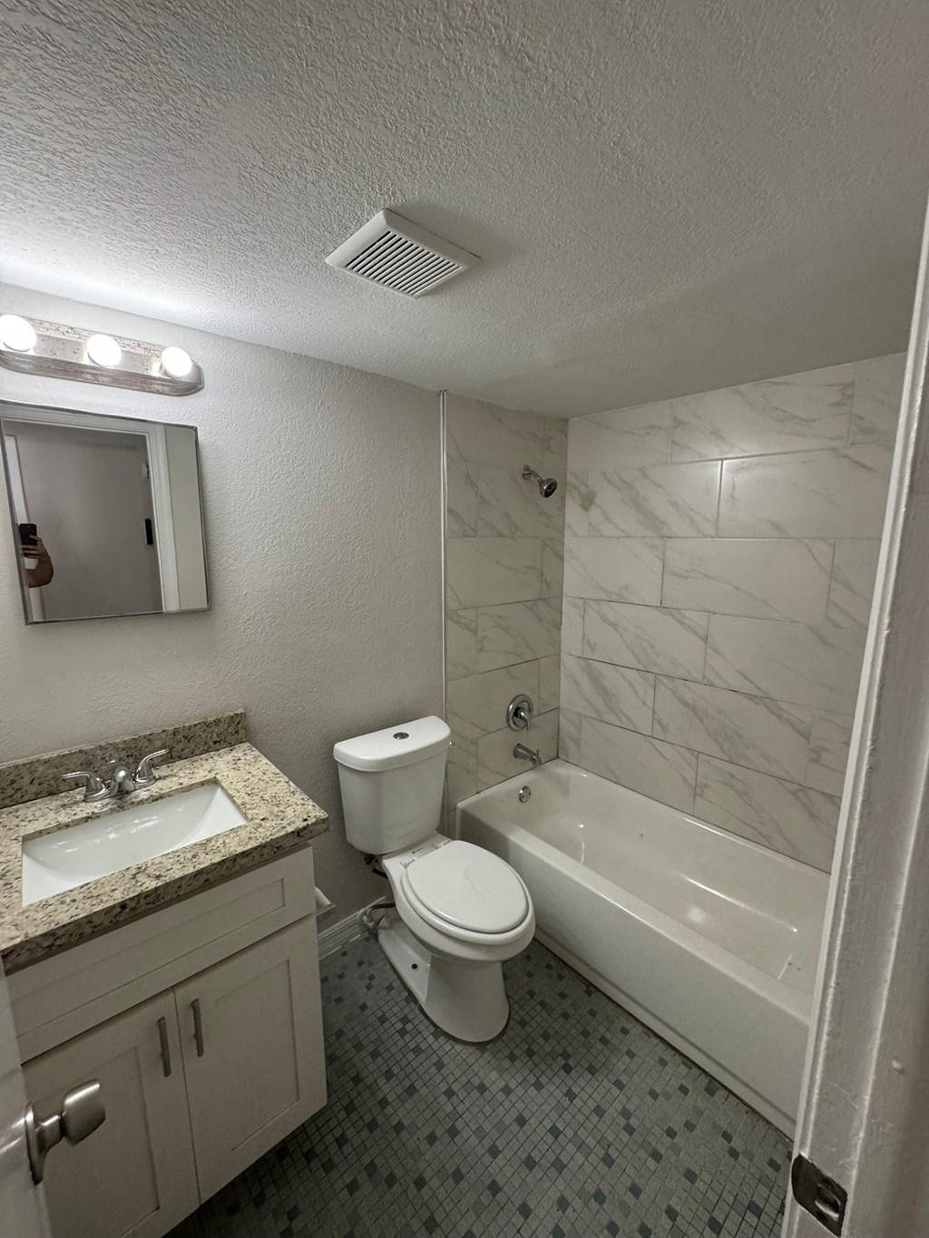 A white toilet sits next to a sink in a bathroom.