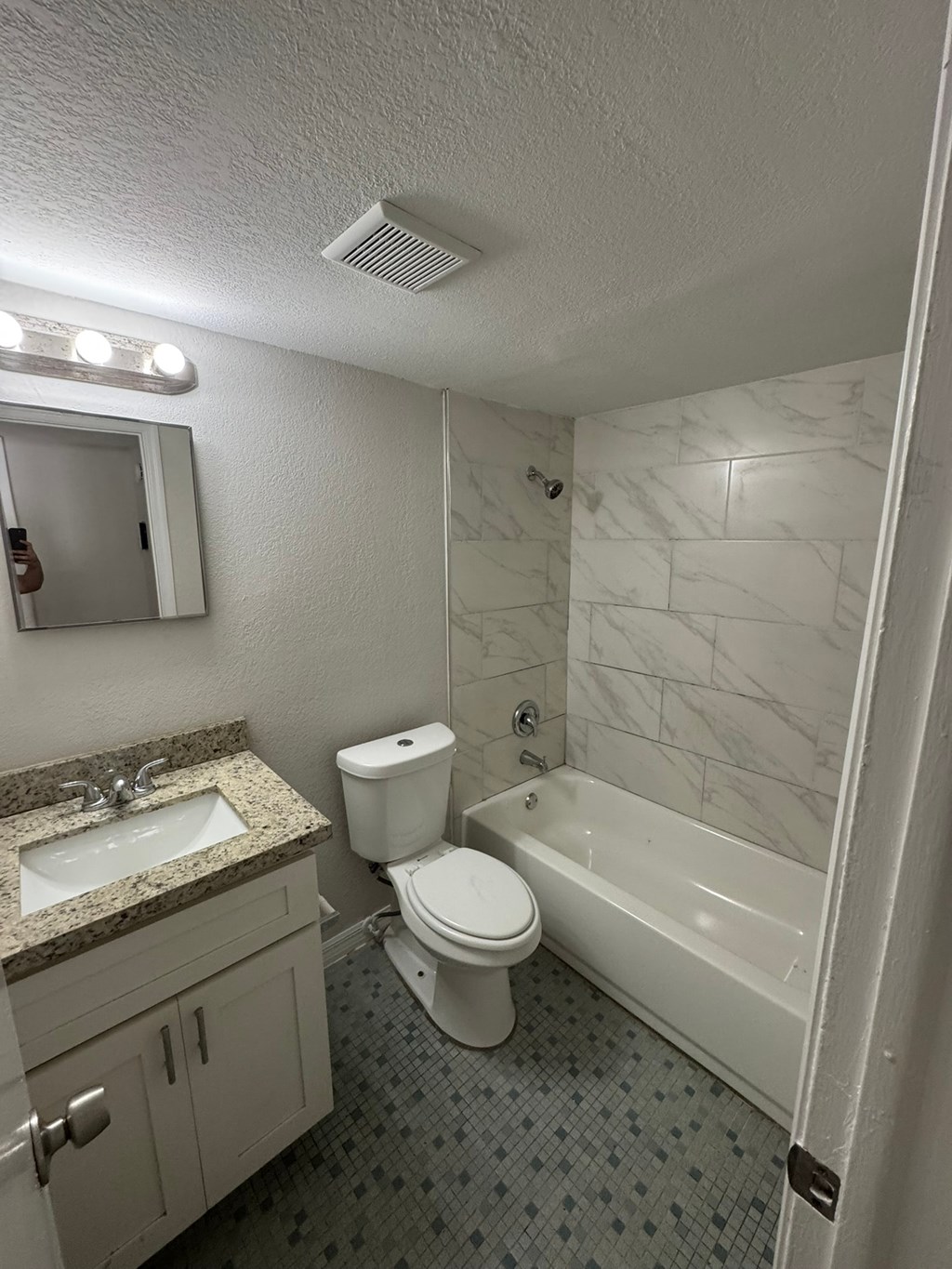 A white toilet sits next to a sink in a bathroom.