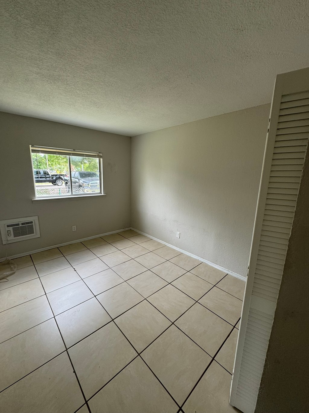 A room with a window and tiled floor.