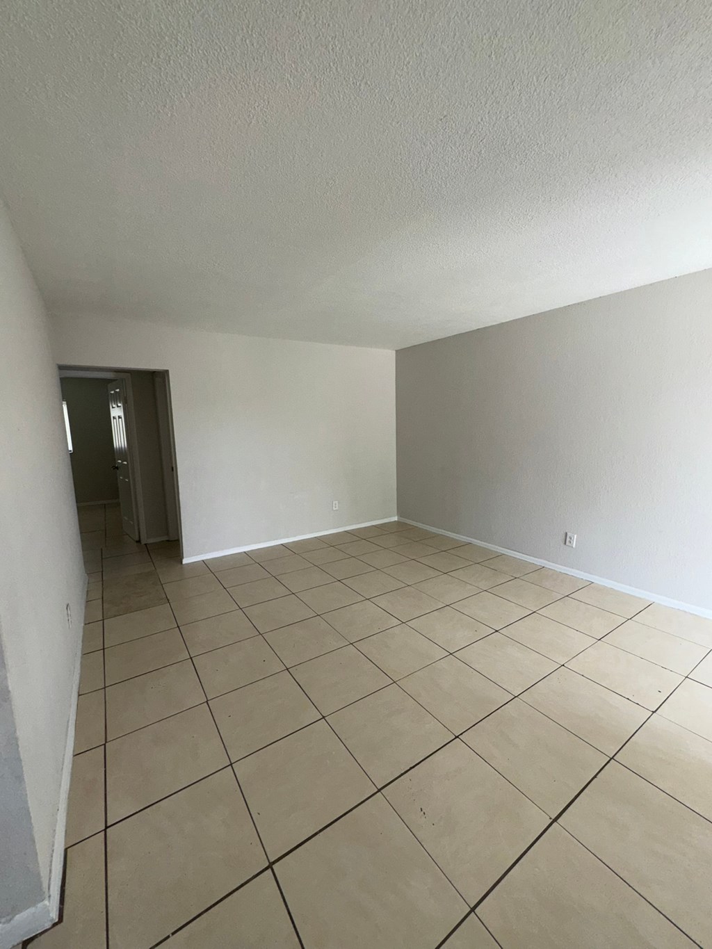 A room with a tiled floor and a door in the background.