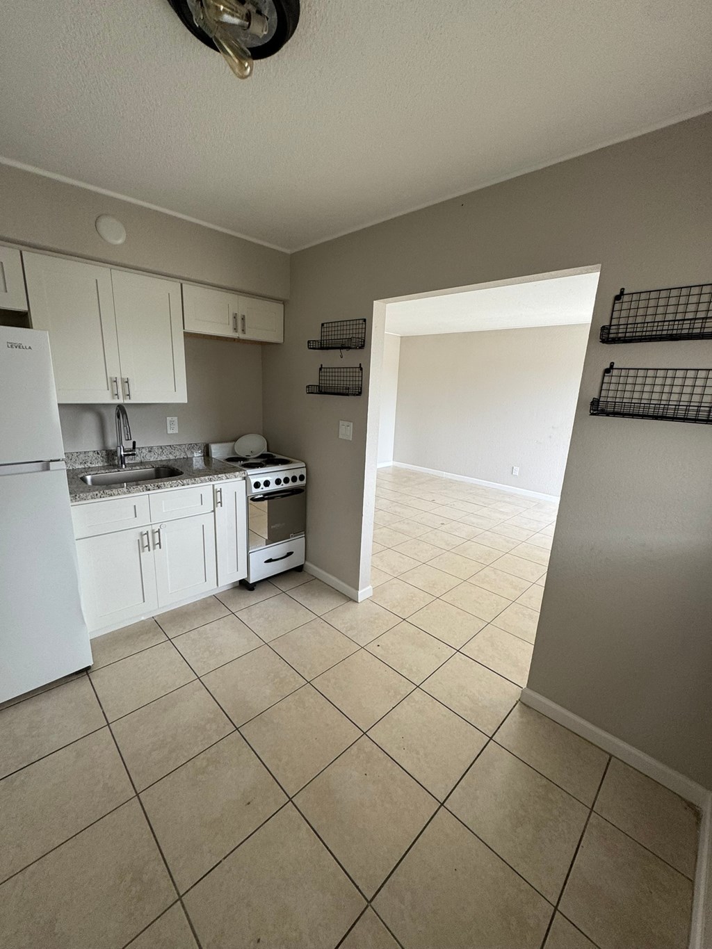 A kitchen with white appliances and white cabinets.