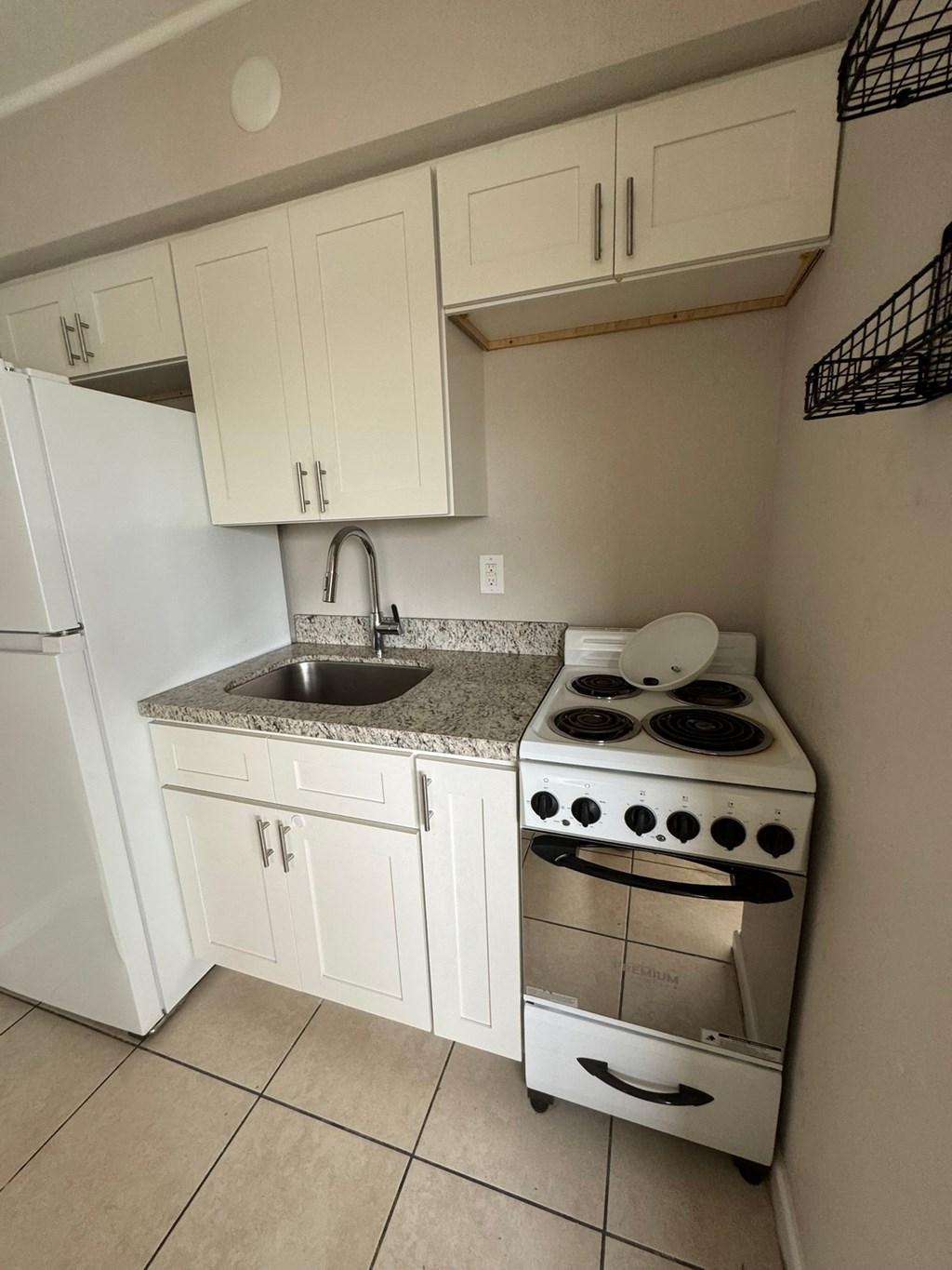 A white kitchen with a stove and sink.