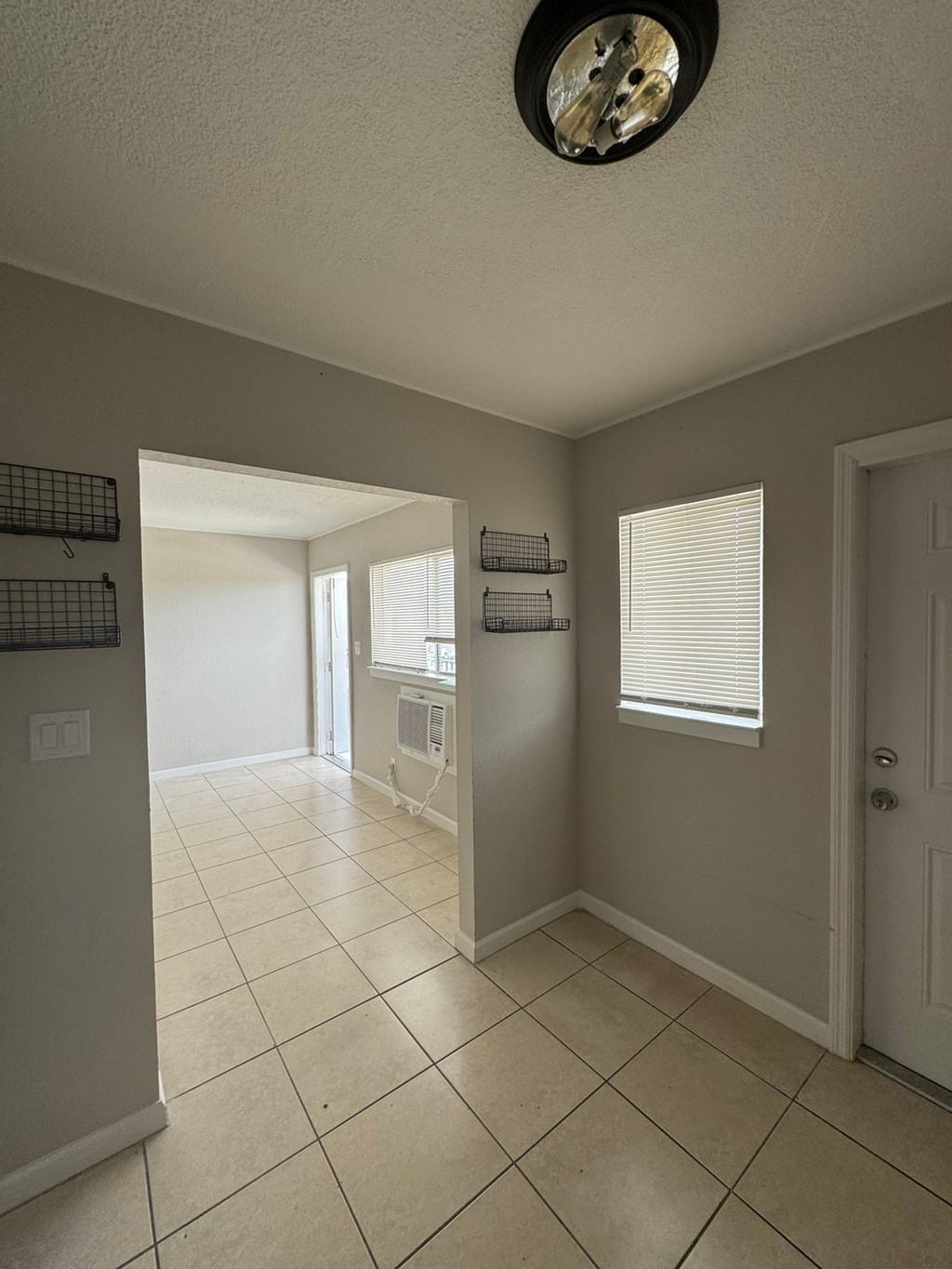 A kitchen with a white tile floor and a white door.