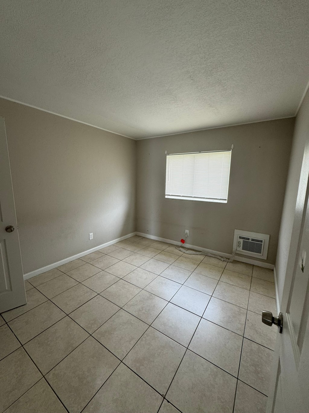 A room with a window and a microwave in it.