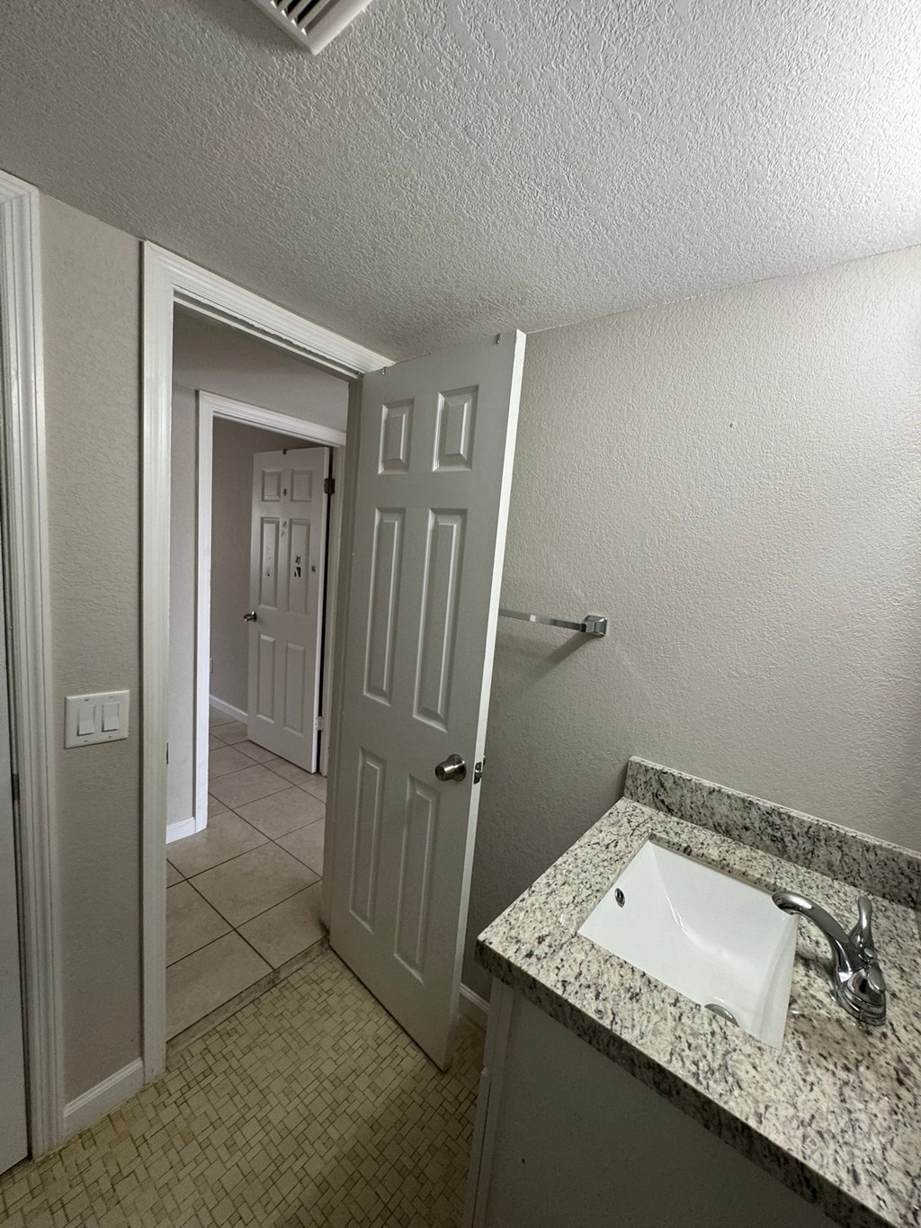 A bathroom with a sink and a door.