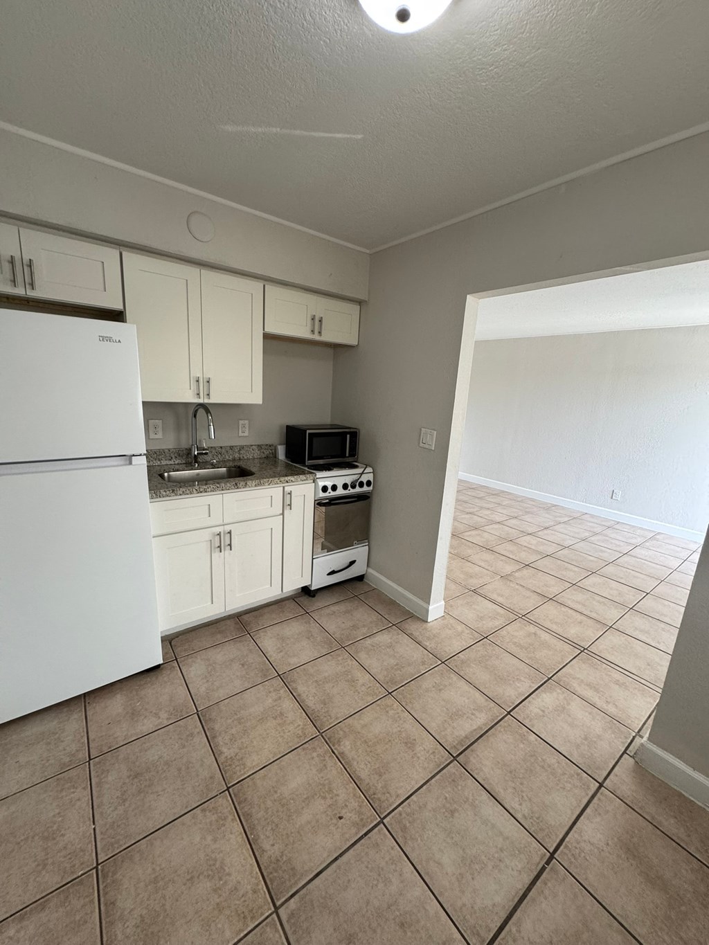 A kitchen with white appliances and white cabinets.
