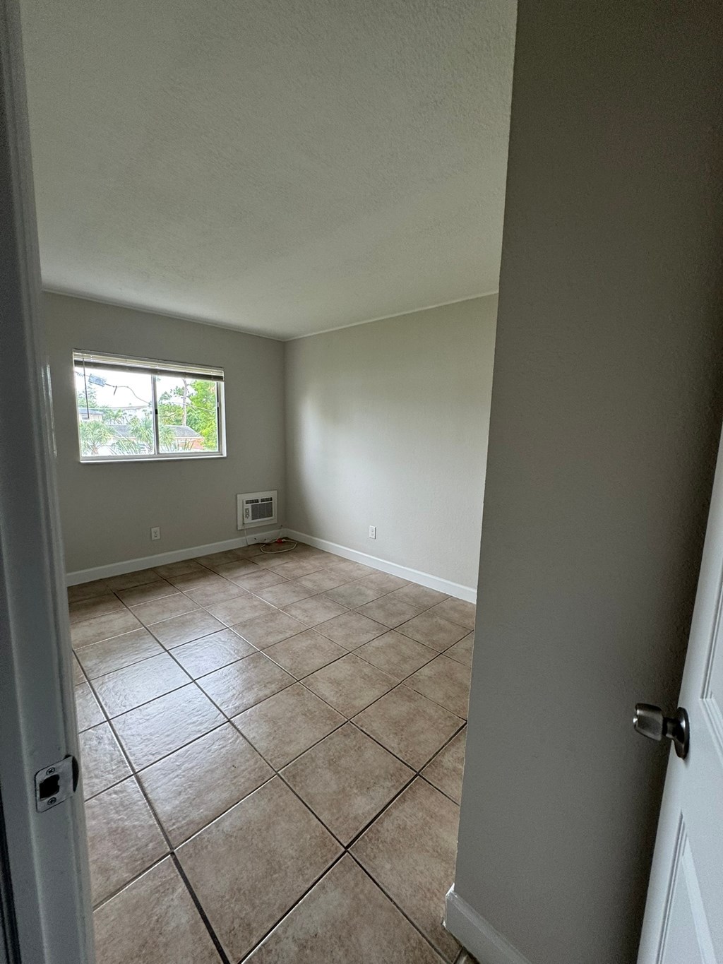 A room with a tiled floor and a door.