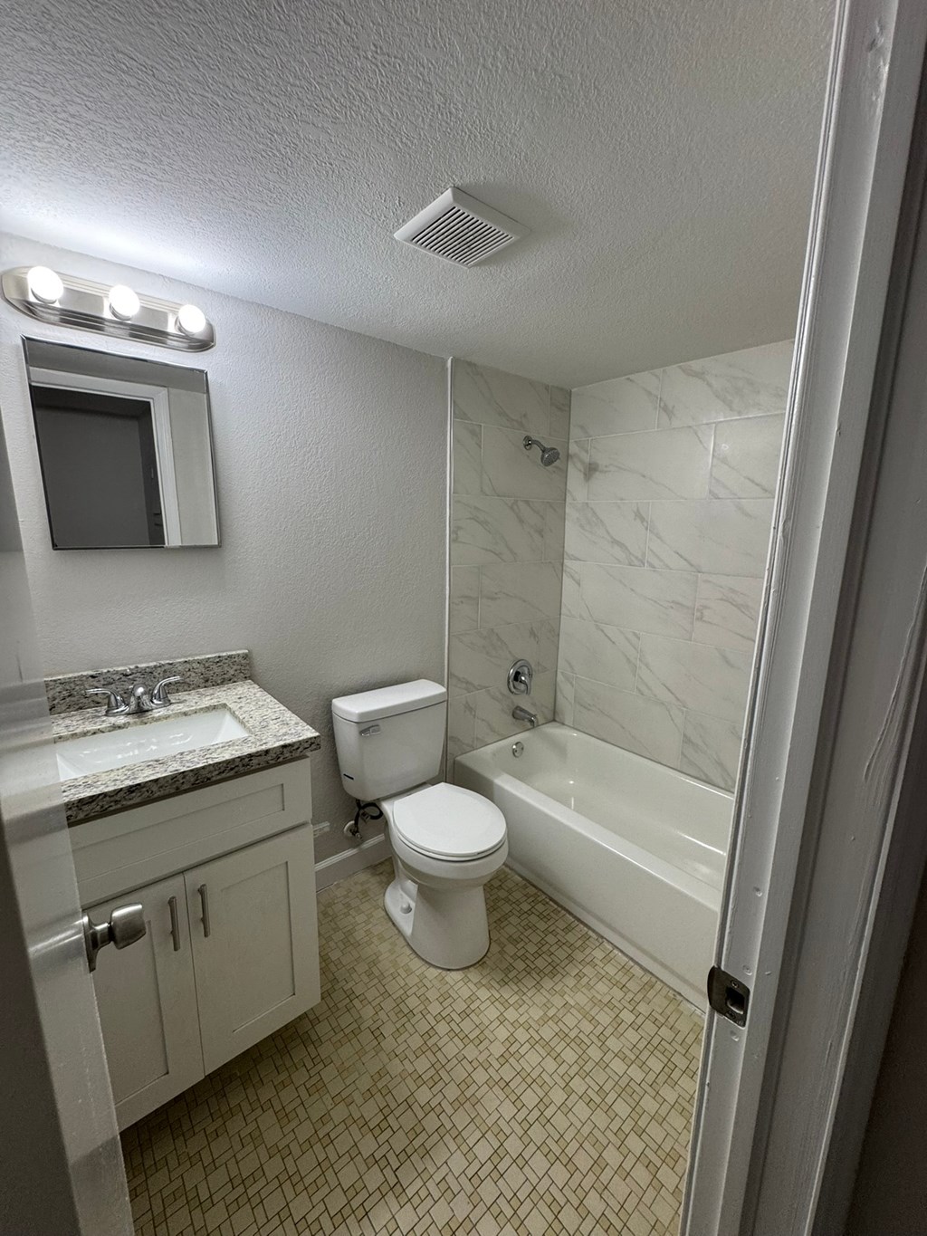 A bathroom with a toilet, sink, and bathtub.