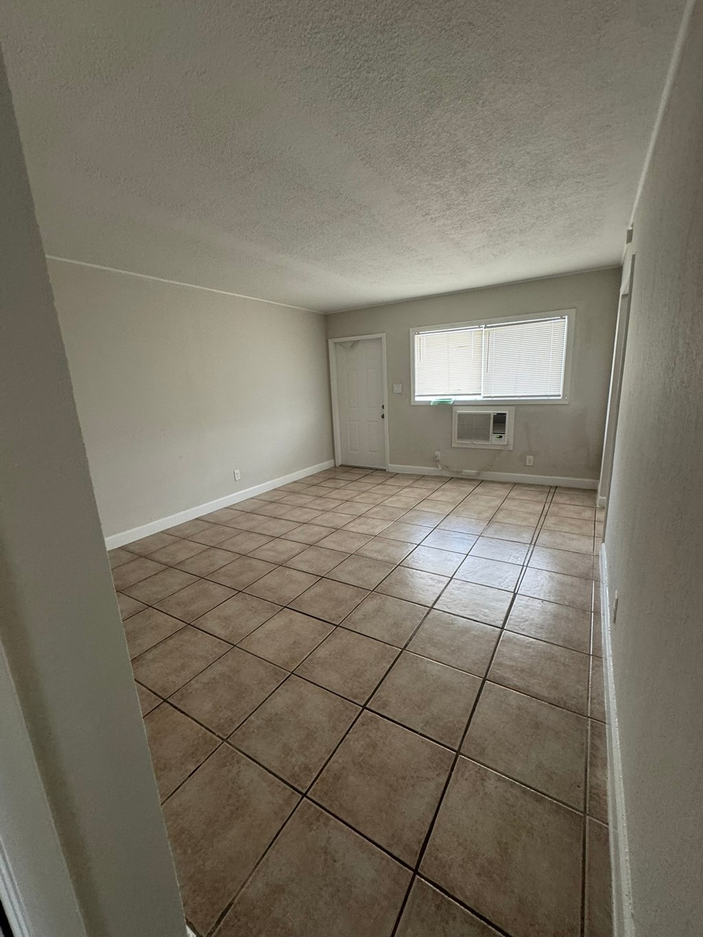 A room with brown tile flooring and white walls.
