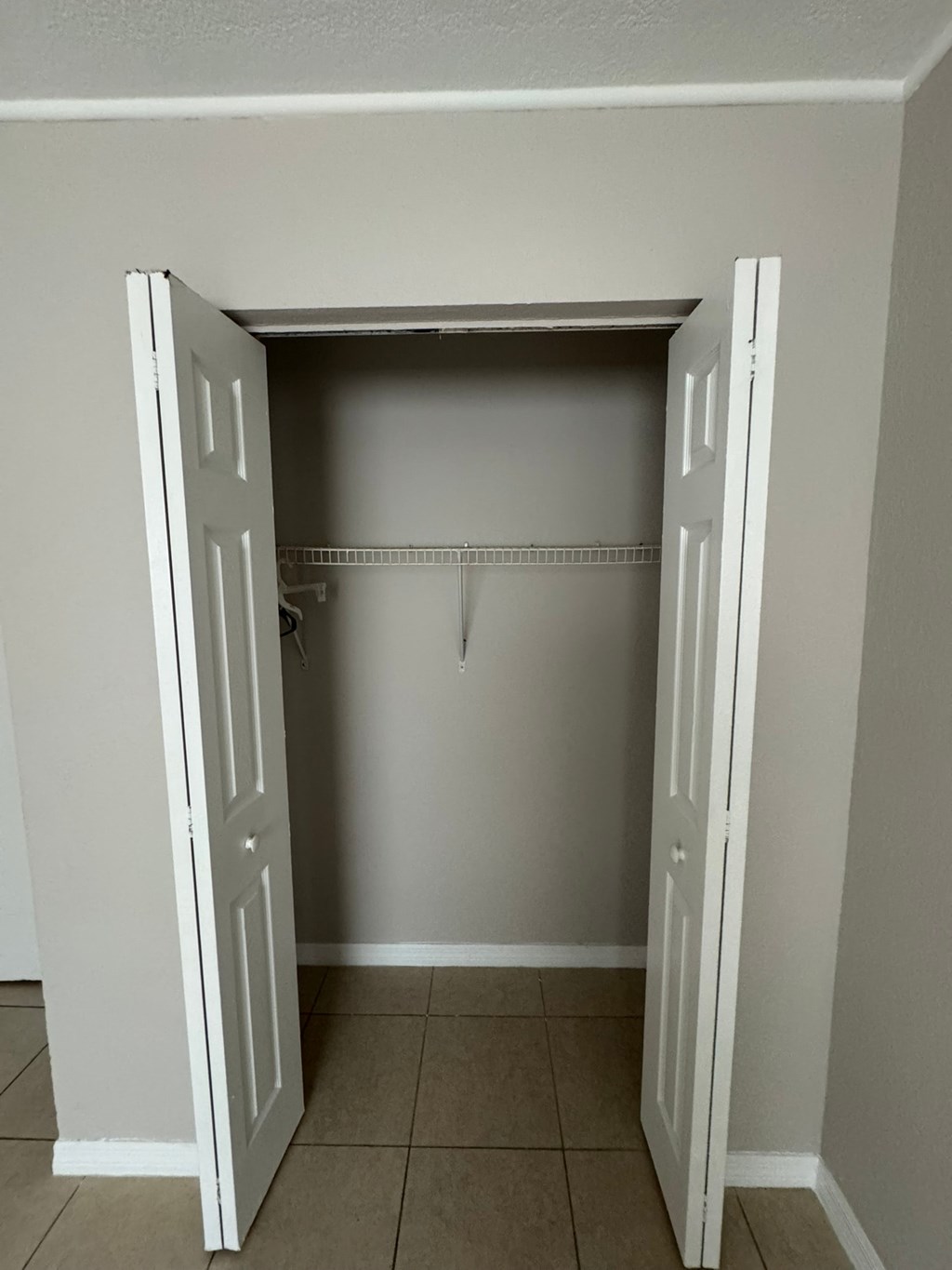 A white closet with a shelf and rod.