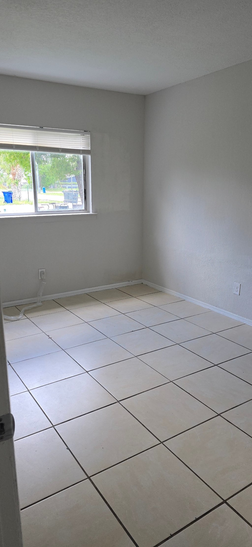 A room with a window and tiled floor.