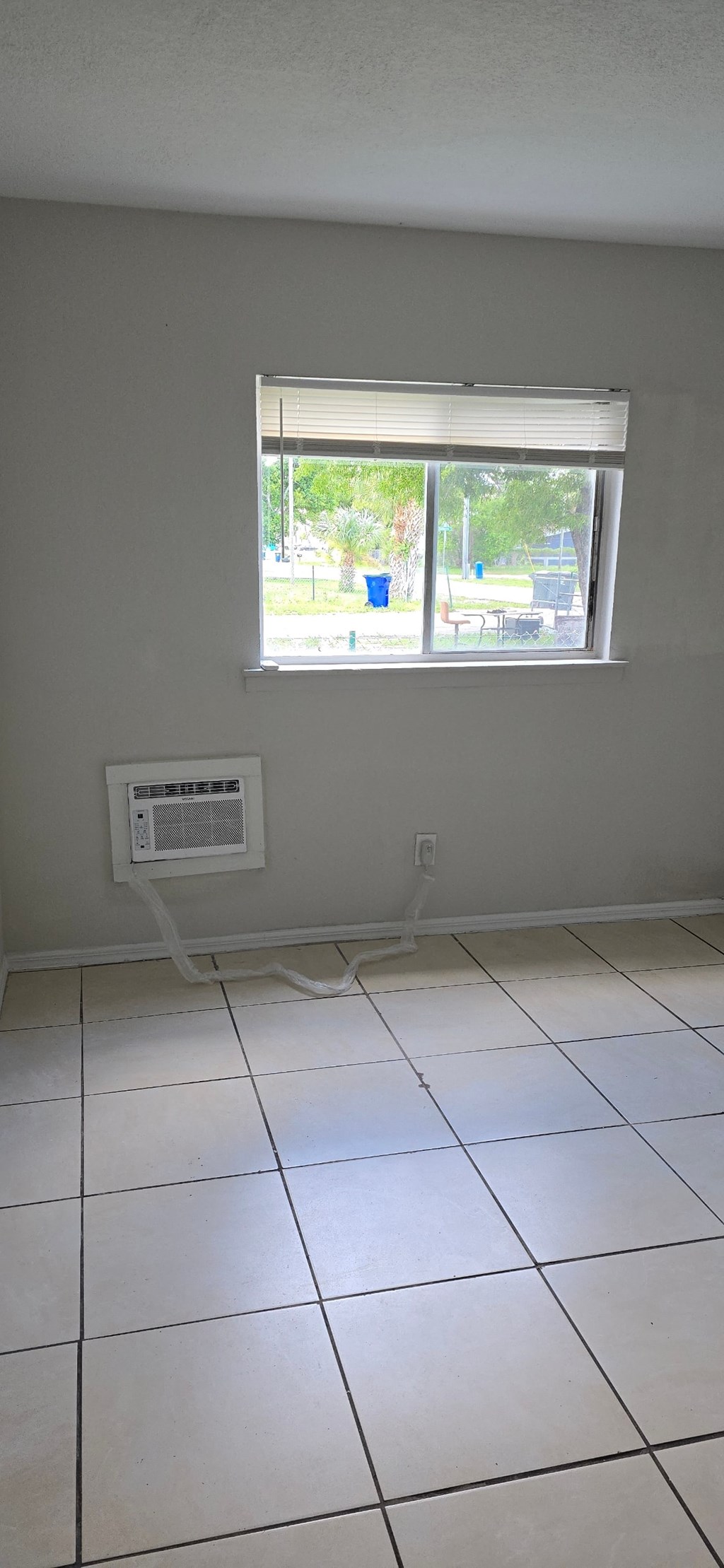 A room with a window and a tiled floor.