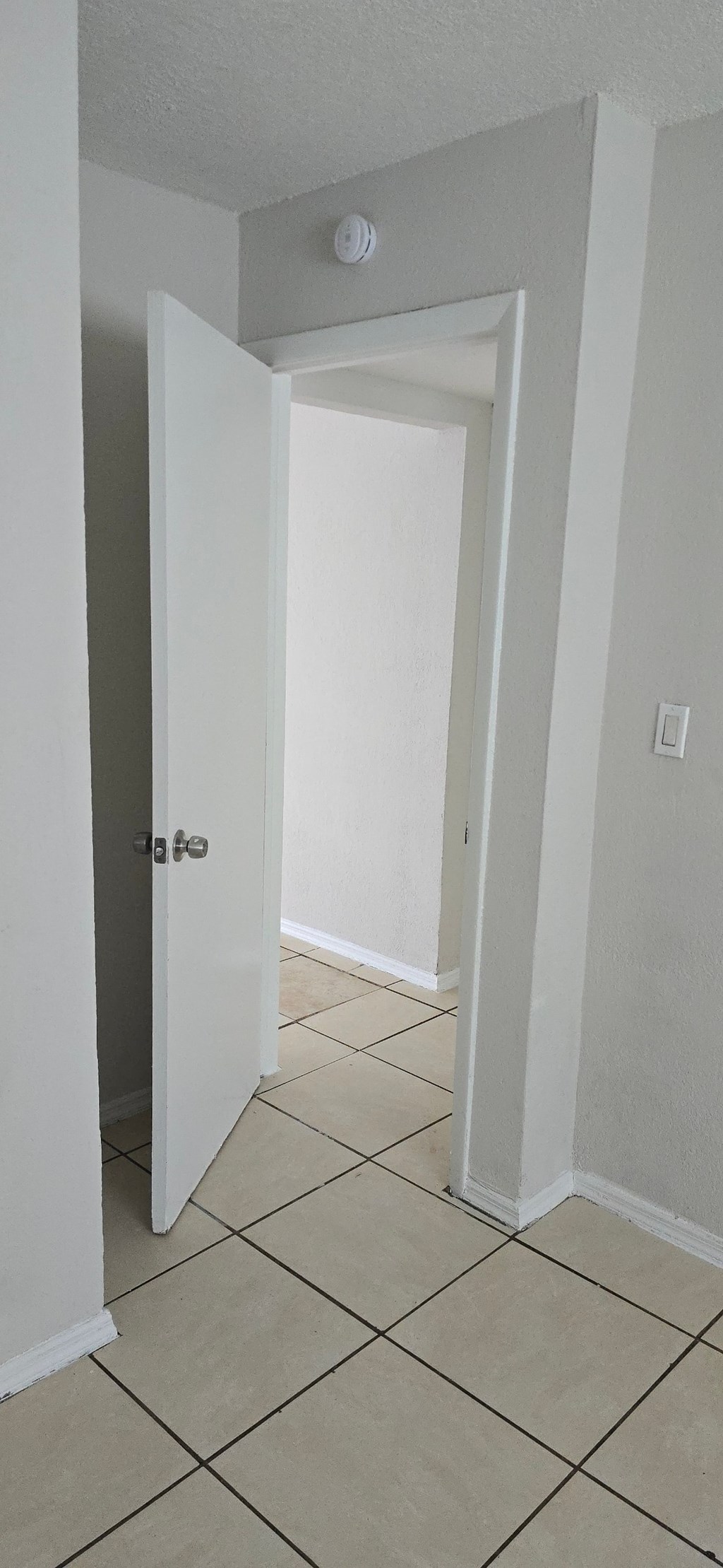 A white door is open to a hallway.