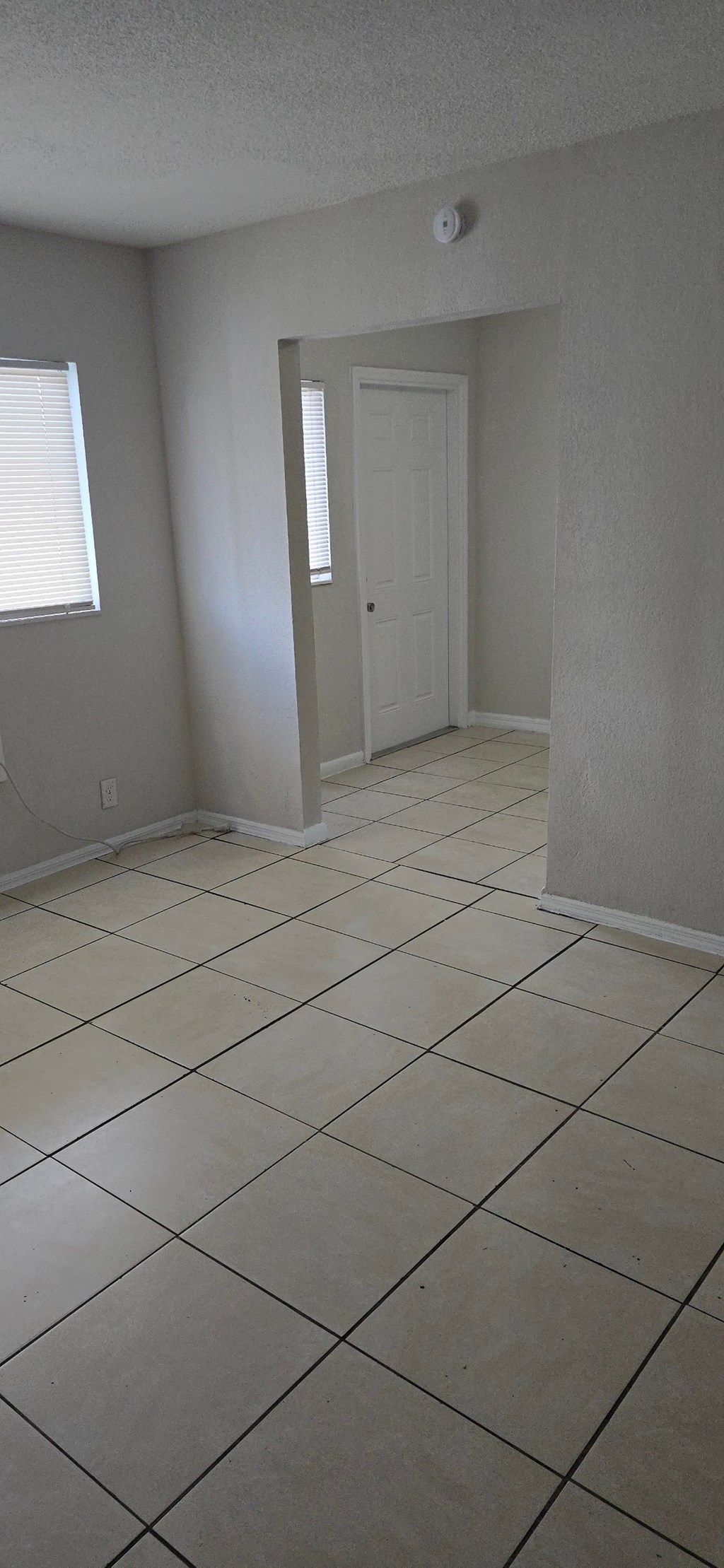 A room with a white door and tiled floor.
