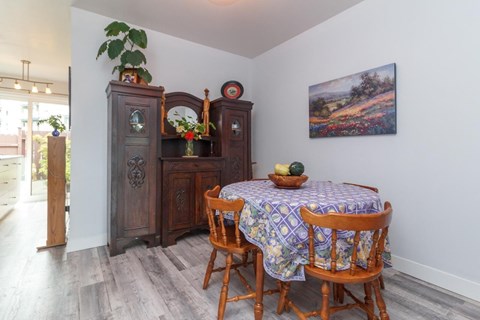 A dining room with a wooden table and chairs.