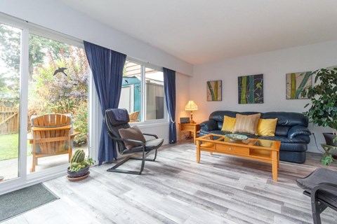 A living room with a blue couch and a wooden chair.
