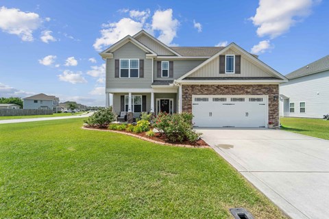 A house with a grey roof and a garage door.