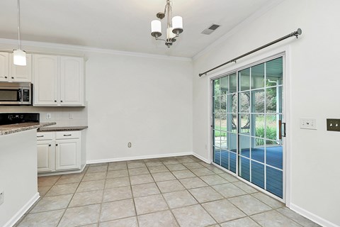 A kitchen with white cabinets and a microwave.