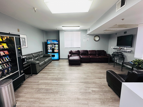 A living room with a couch, a television, and a vending machine.