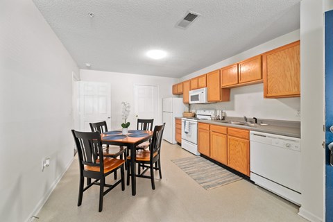 A kitchen with a table and chairs in the middle of the room.