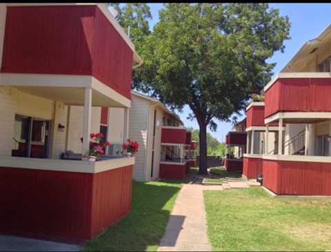 A red and white building with a tree in front.