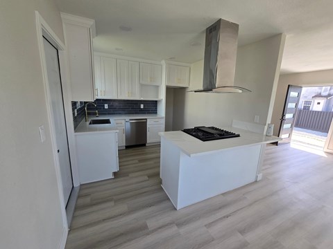 A modern kitchen with white cabinets and a large island.