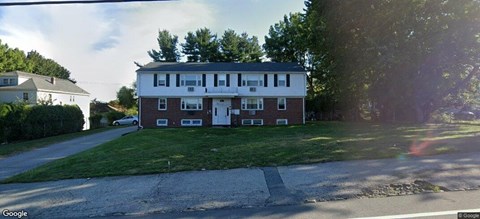 A two-story brick house with a white door and windows.