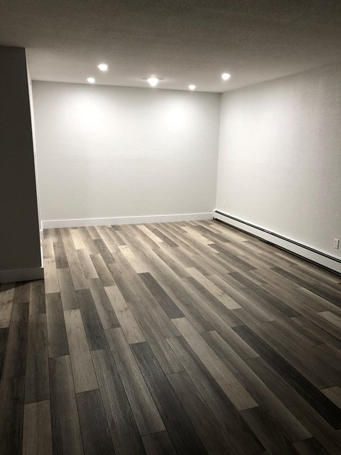 A room with a wooden floor and white walls.