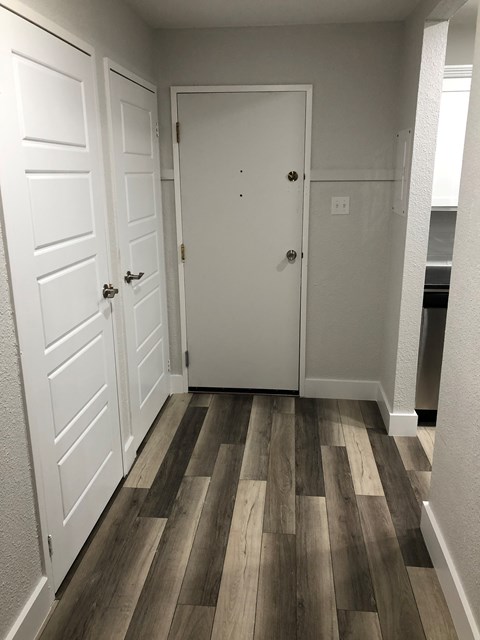 A hallway with a white door and a white cabinet.