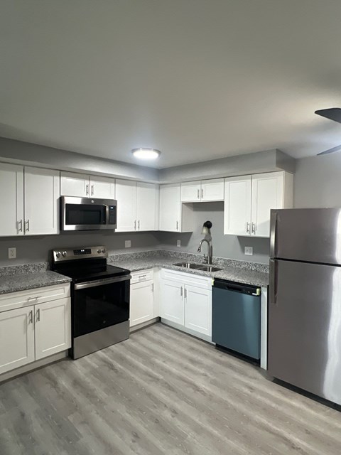 A kitchen with white cabinets and a black stove top oven.