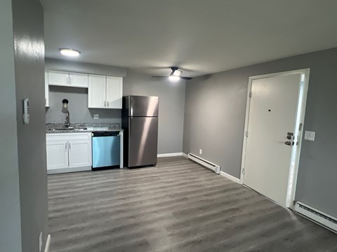 A kitchen with a refrigerator and a sink.