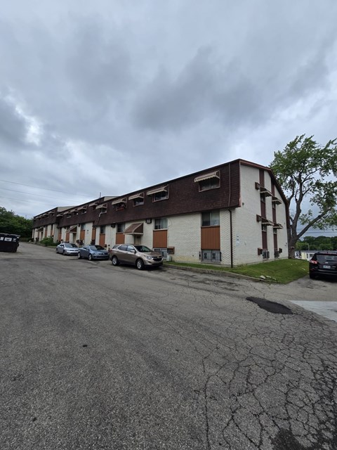 A parking lot with cars and a building in the background.