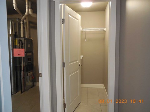 A white door is open to a small, empty room.