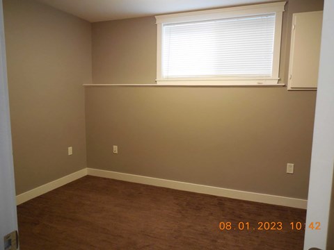 A room with a window and a wall socket.