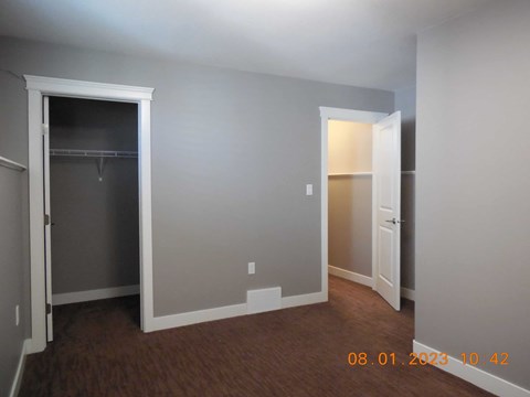 A room with a door on the left and a closet on the right.