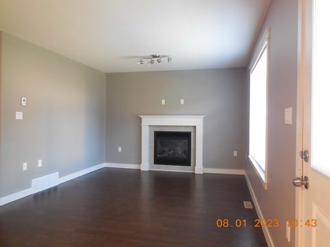 A room with a fireplace and wooden floors.