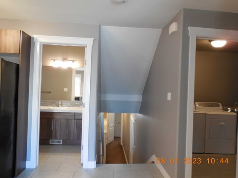 A kitchen with a refrigerator, sink, and cabinets.