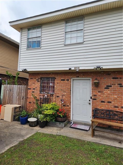 A house with a white door and a brick wall.