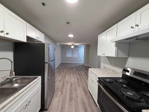 A kitchen with black appliances and white cabinets.