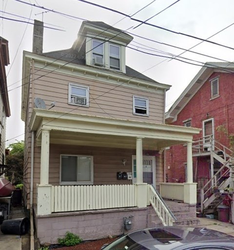 A house with a brown roof and a white porch.