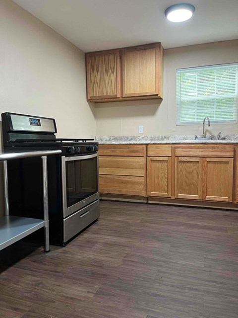 A kitchen with wooden cabinets and a black stove top oven.