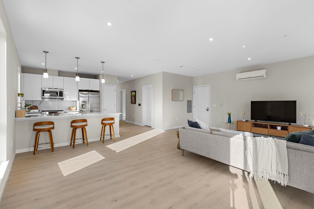 A modern open plan living and kitchen area with a grey sofa.