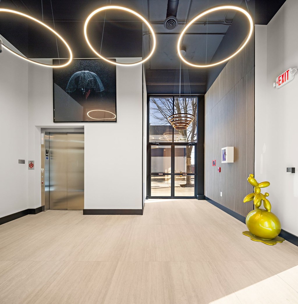 A hallway with a yellow sculpture and a painting on the wall.
