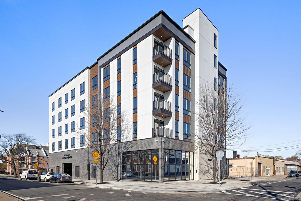 A modern multi-story building with a white and brown facade and a grey base.