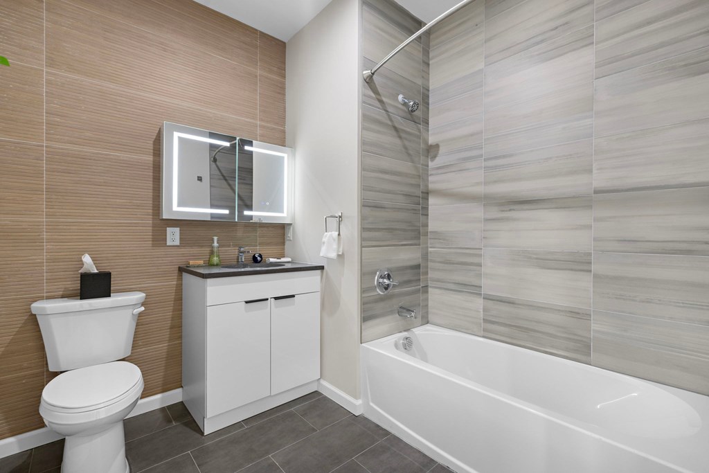 A bathroom with a white toilet, sink, and bathtub.