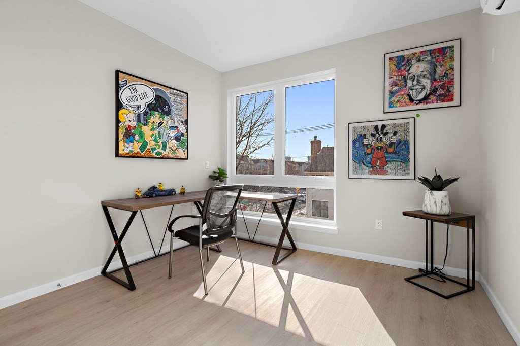 A room with a desk and chairs and pictures on the wall.
