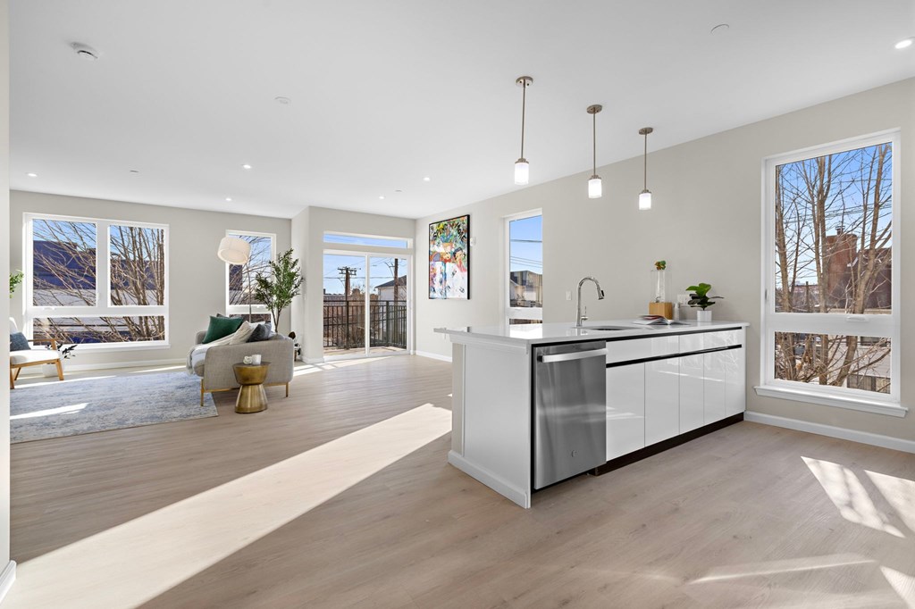 A modern kitchen with a large island and pendant lights.