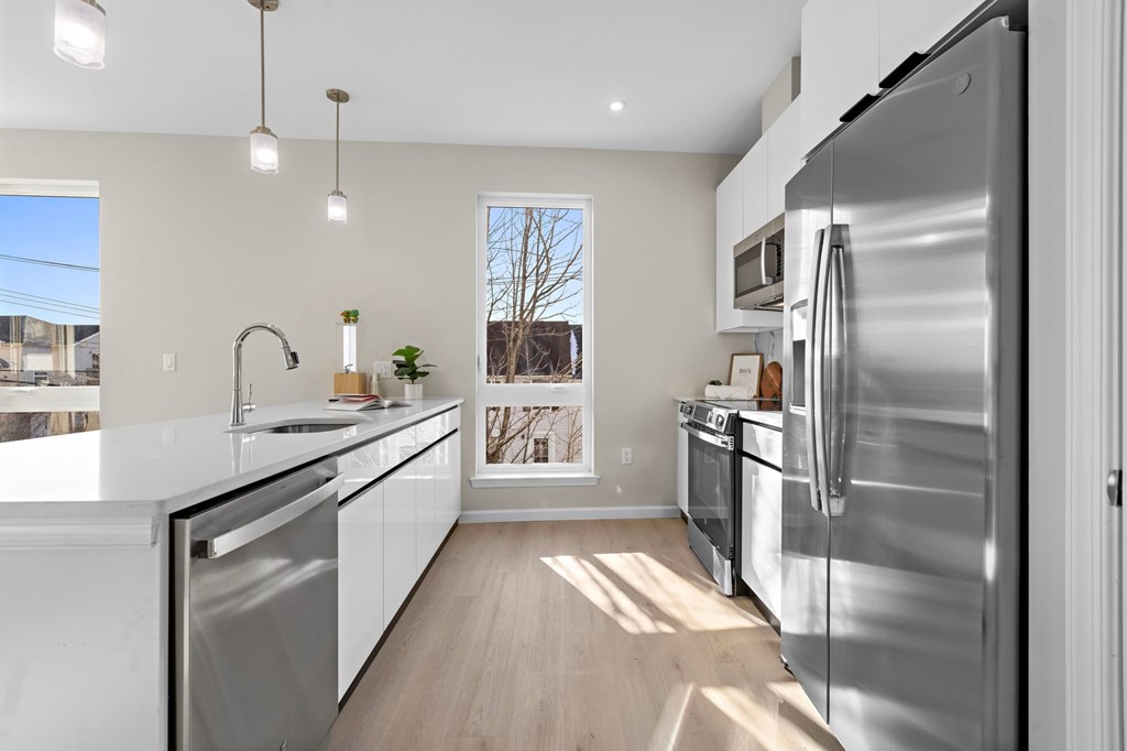A modern kitchen with stainless steel appliances and white cabinets.